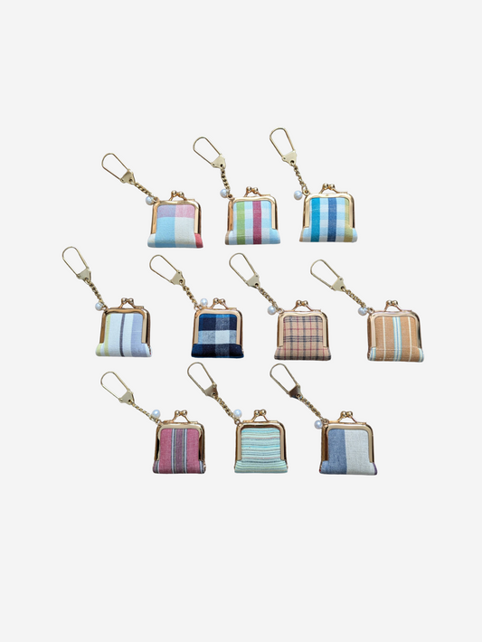 Set of small fabric pouches with keychains on a white background